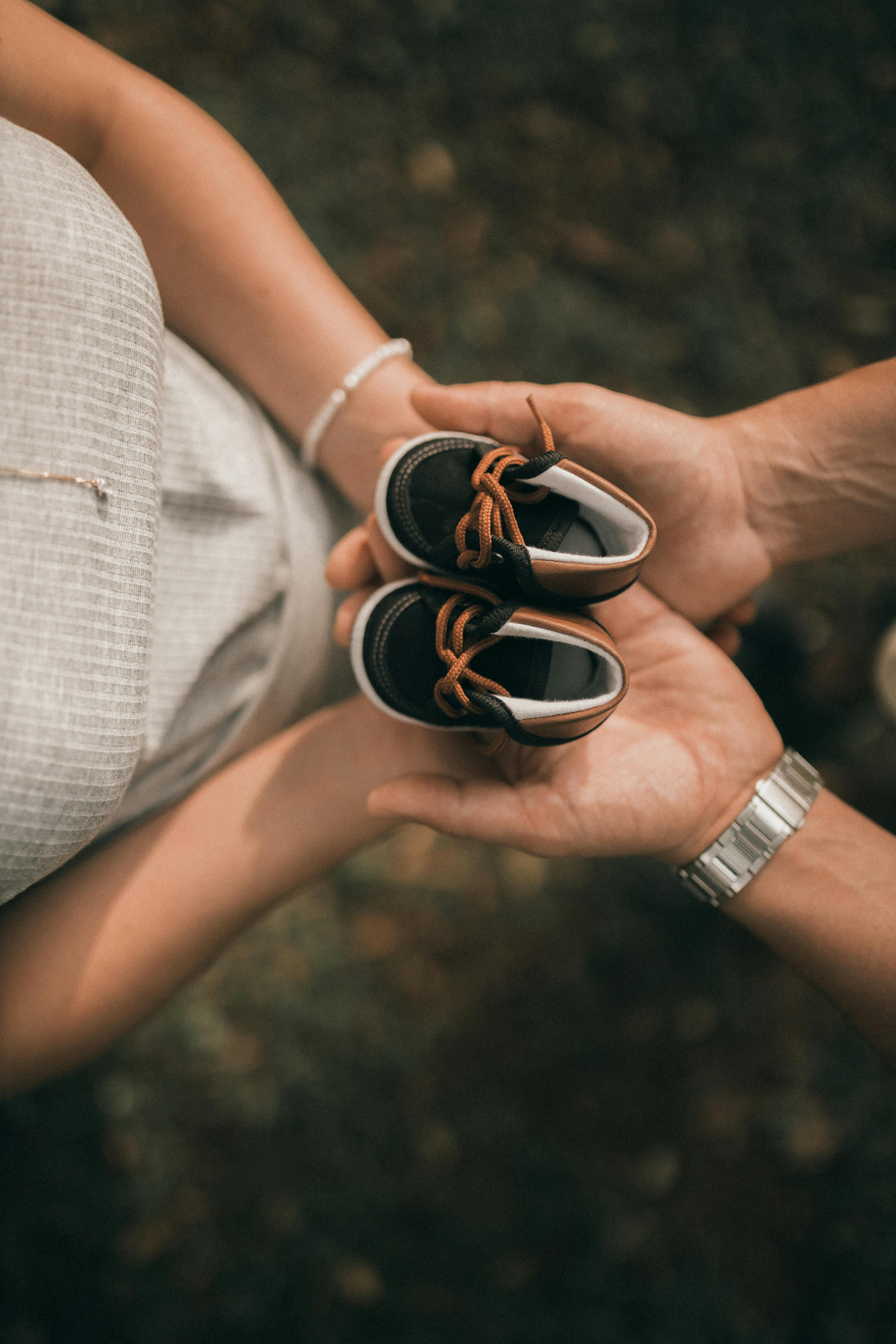 Expecting parents holding baby shoes - fertility care and family planning support