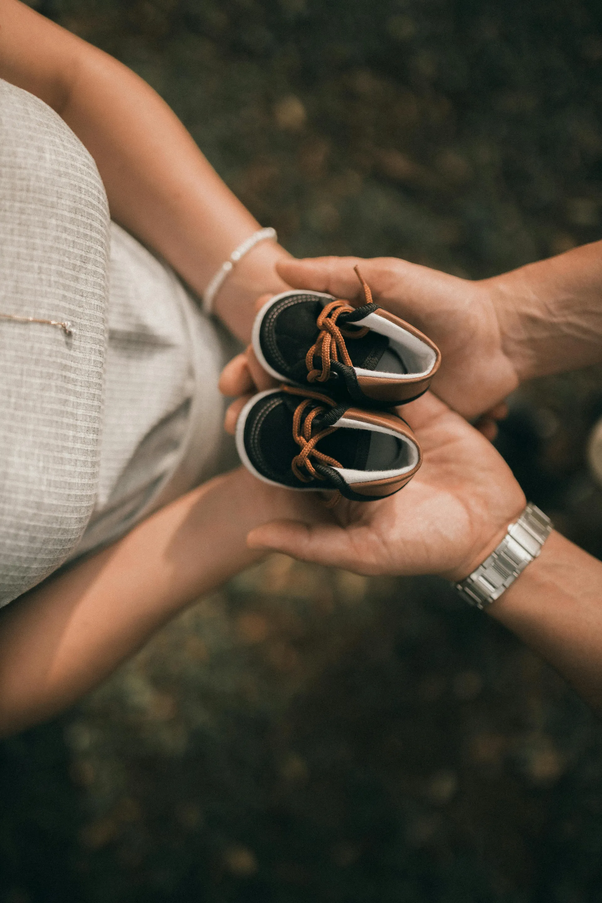 Expecting parents holding baby shoes - fertility care and family planning support